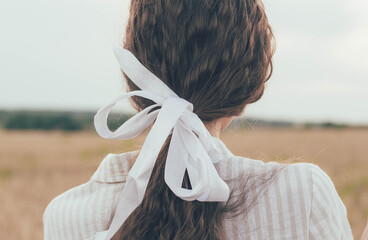 girl's hair braided in a ribbon
