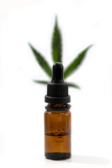 cannabis oil, cannabis, marijuana on a white background in a pipette bottle with a blurred leaf behind