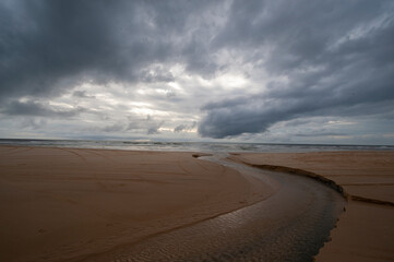 Fototapeta na wymiar dark clouds over the sandy beach