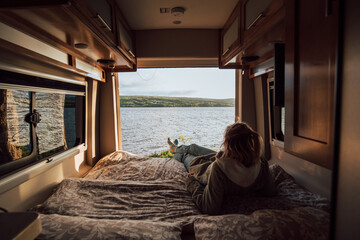 The girls is enjoying a view from the campervan bed on Cape Breton Island 