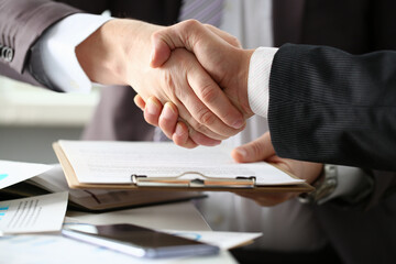 Close up of business people shaking hands while finishing their meeting. Collaborative teamwork. Business deal concept