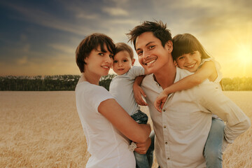 portrait of a happy and smiling family in a wheat field under a sunset