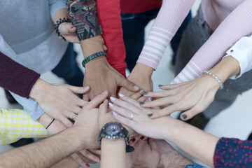 Multiracial Group of college students with Hands in Stack, Teamwork