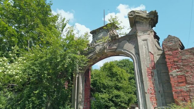 Partly ruined arched gate of old historic building - landmark of german prussian architecture in Kaliningrad, Russia (formerly Koenigsberg) at sunny spring day. Low angle view rendered in 4K