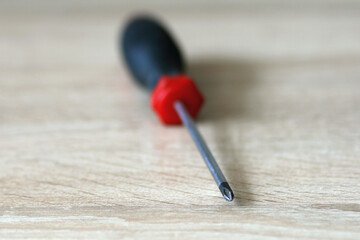 Cross-shaped screwdriver with red and black handle