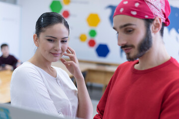 Two young hardworking student having a conversation in the classroom