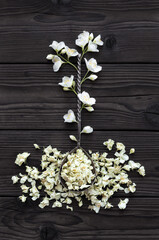 Jasmine fresh and dried on a wooden table. Composition of fresh and dried jasmine flowers in an old metal spoon. For tea or making essences, cooking, medical and cosmetology