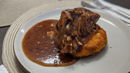 Roasted pork with mushroom gravy on potato cake