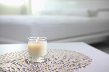 the luxury lighting aromatic scented glass candle display on the grey table to creat romanic and relax ambient in the white bedroom near sunlight from the curtain window on valentine day