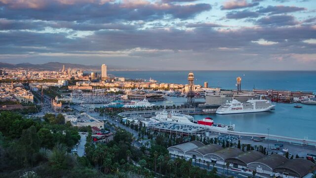 Barcelona, Spain, zoom out timelapse view of sunset over the Port of Barcelona, the largest in Catalonia and one of the most important ports in Europe.