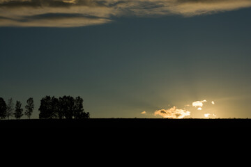 丘に沈む太陽と夕焼け雲