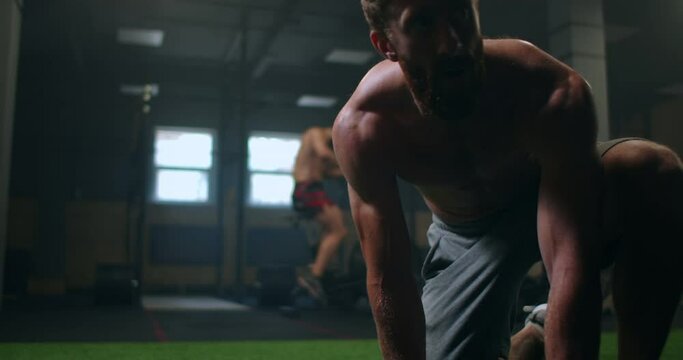 a tired man gets up from the floor after training and continues to move forward despite fatigue. overcome difficulties and achieve your goals