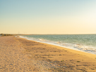 deserted beach at sunset with wind generators