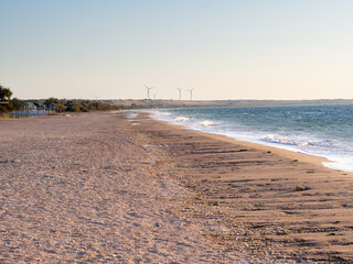 deserted beach at sunset with wind generators