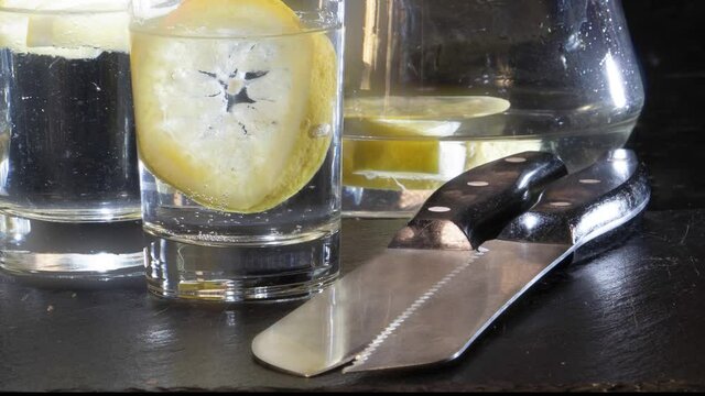 Glas Wasser mit Eis auf schwarzem Hintergrund.