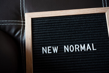 white text new normal on black felt letter board