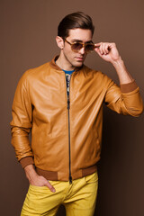 The man goes, runs in bright court and bright clothes with prints, yellow jeans and dark glasses. 