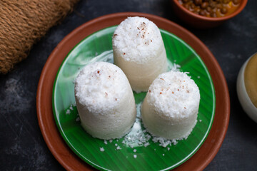 Popular South Indian breakfast puttu / pittu made of white rice flour and coconut in a bamboo mould, with banana, Kerala, India. Bamboo puttu prepared in the bamboo utensil. 