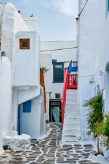 Picturesque scenic narrow Greek streets with traditional whitewashed houses with blue doors windows...