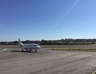 Large business jet parked at airport on sunny day