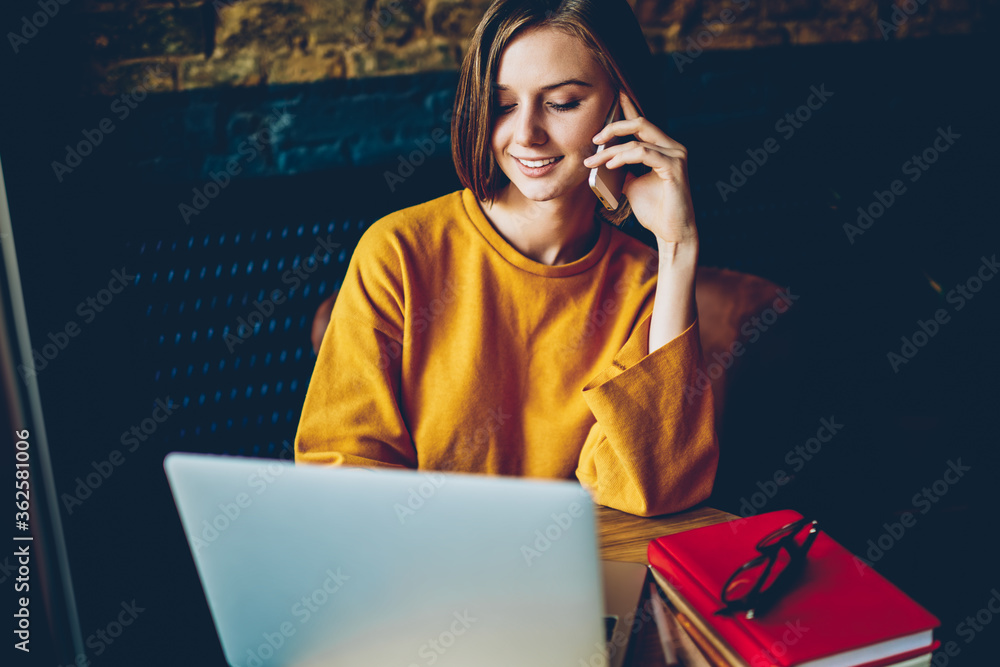 Aufkleber pretty student working at computer while talking on cellular with service operator about banking acc