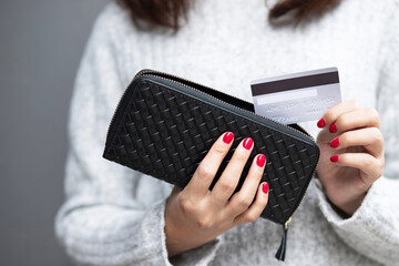 woman person holding a wallet in the hand of a  take credit card out of pocket. Cost control...
