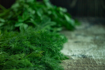 Green spicy herb dill and parsley on a dark old wood background, defocused photo
