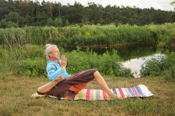 Handsome fit man doing yoga at the park