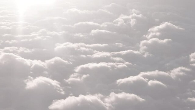 Soothing calm aerial plane footage of white puffy clouds flying hovering above the ground up in the heavenly sky air with ease breezing in the wind meditating yoga above the seas and rain cities