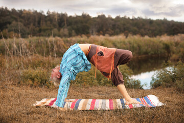 Handsome fit man doing yoga at the park