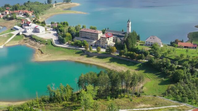 Rama Lake in Bosnia and Herzegovina with Franjevacki samostan Monastery below, Aerial flyover shot