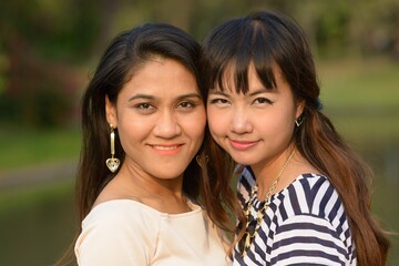 Portrait of two young Asian women together at the park