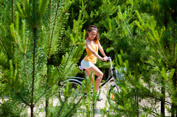 Woman in vintage shorts on bicycle. girl cycling in fir tree forest. girl riding bike. on bicycle in sunny park. enjoying ride on warm summer day. Sport mountain bike. Active people. speed and sprint