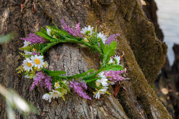 Flowers wreath on tree texture surface. 7th July, traditional slavic holiday with fortune-telling...