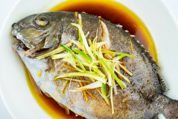 A dish of home-cooked steamed brown blue roe on a white background