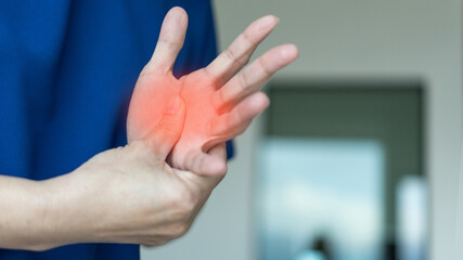 Trigger Finger problems. Woman’s hand with red spot o fingers as suffer from Carpal tunnel...