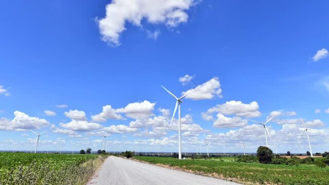 Time Lapse of Windmills for electric power production with white cloud and blue sky at Huai Bong, Dan Khun Thot district, Nakhon Ratchasima THAILAND. renewable energy and save  environmental concept.