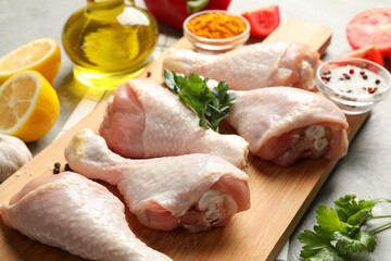 Board with raw chicken meat on gray background. Cooking chicken