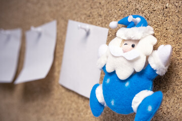 toy Santa Claus in blue and a to-do list next to him