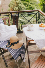 Breakfast with fresh tea, fruits and cookies outdoors on a cozy terrace of country house or cottage with garden view.