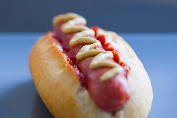 One homemade classic hot dog with yellow mustard and ketchup.American Fast Food. National holiday hot dog Day.Close up.Small depth of field.