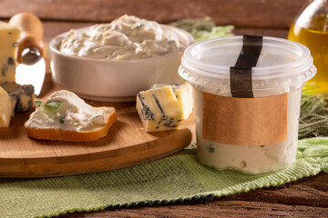 Blue cheese cream and toasted bread on wood background. Pate de gorgonzola in Brazil