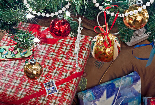 This is some beautifully wrapped Christmas gifts closeup, under a decorated and lit Christmas tree, for a horizontal holiday image.