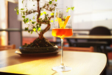Japanese style cocktail with lemon zest in wineglass, toned