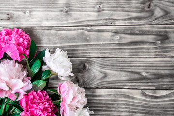 Bouquet colorful pionies on gray shabby wooden background. Universal greeting card. Surfese flalay