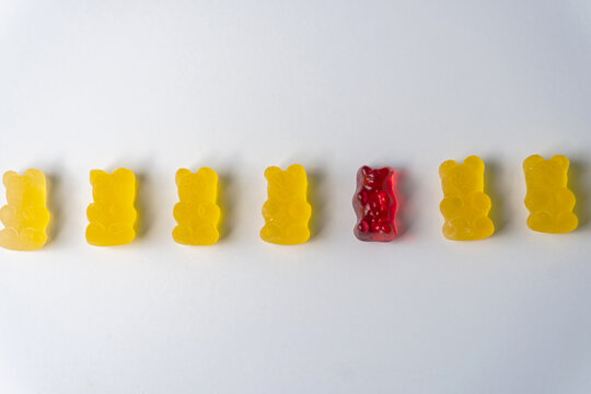 Row Of Yellow And Red Jelly Bears Candy On A White Background.