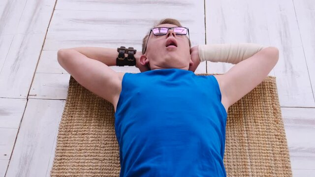Funny nerd panting while exercising at home on the floor
