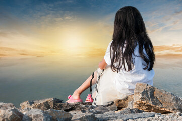 Fototapeta na wymiar young woman sitting on the rocks
