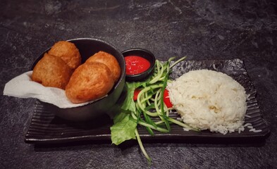 Chicken in tempura and rice served on a plate