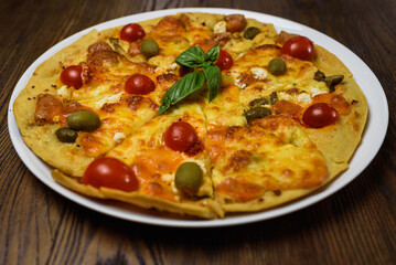 
pizza with meat and tomatoes under cheese